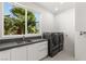 Bright laundry room with modern washer and dryer, ample counter space, and large window at 2293 Buckingham Ct, Henderson, NV 89074