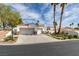 Attractive single-story house featuring a two-car garage, palm trees and well-manicured lawn at 230 Pintale Cir, Henderson, NV 89074