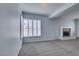 Living room with a fireplace, a grey carpet, and bright window shutters at 230 Pintale Cir, Henderson, NV 89074