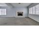 Open-concept living room featuring a fireplace, plantation shutters, and neutral carpeting at 230 Pintale Cir, Henderson, NV 89074