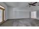 Bright living room featuring plush carpeting, ceiling fan, and a door leading to the backyard at 230 Pintale Cir, Henderson, NV 89074