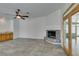 Living room with stone fireplace, ceiling fan, built-in bar, and access to the sunroom at 230 Pintale Cir, Henderson, NV 89074