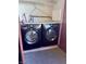 A black front load washing machine and dryer are under a shelf with water hookups at 2451 N Rainbow Blvd # 2076, Las Vegas, NV 89108