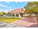 Inviting single-story home featuring a red tile roof, unique arches, and a well-manicured lawn at 2501 Wimbledon Dr, Las Vegas, NV 89107