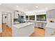 Modern kitchen featuring stainless steel appliances, a large island, gray cabinetry, and large windows for natural light at 2501 Wimbledon Dr, Las Vegas, NV 89107