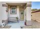 Cozy front porch with decorative elements like a wrought iron bench and hanging plants at 2537 Nashira St, Henderson, NV 89044