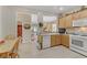 Eat-in kitchen with adjacent dining and living area views, featuring wood cabinets and stainless dishwasher at 2537 Nashira St, Henderson, NV 89044