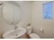 Cozy half bathroom with modern fixtures, pedestal sink, and bright window at 2657 Fawn Beige Ct, North Las Vegas, NV 89086