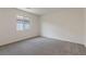 A carpeted bedroom with a window overlooking a backyard at 2728 Pavehawk Way, Las Vegas, NV 89156