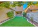 Spacious backyard featuring low-maintenance artificial grass and a covered patio area at 3204 Romanesque Art Ave, Henderson, NV 89044