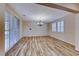 Open dining area with wood-look tile floors, chandelier, and bright, natural lighting at 3204 Romanesque Art Ave, Henderson, NV 89044