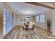 Dining area featuring a large table setting, modern chandelier, and sliding door at 3204 Romanesque Art Ave, Henderson, NV 89044