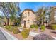 Two story home with stucco exterior and mature landscaping in the front yard on a sunny day at 3204 Romanesque Art Ave, Henderson, NV 89044