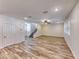 Spacious living room with wood-look tile floors leading to the staircase at 3204 Romanesque Art Ave, Henderson, NV 89044