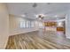 Bright living room featuring wood-look tile flooring, a ceiling fan, and plantation shutters at 3204 Romanesque Art Ave, Henderson, NV 89044