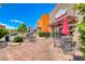 Charming restaurant patio with outdoor seating under umbrellas, set against a brick walkway and lush landscaping at 3204 Romanesque Art Ave, Henderson, NV 89044