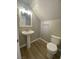 Cozy powder room with a pedestal sink, white toilet, and modern fixtures at 3304 Michelangelo Ct, Las Vegas, NV 89129