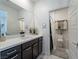 Stylish bathroom with a large mirror, dark cabinets, and an open doorway to the toilet and shower at 3503 Luca Point Ave, Henderson, NV 89044