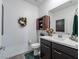 Charming powder room with a decorative wreath, stylish cabinet, and modern vanity at 3503 Luca Point Ave, Henderson, NV 89044