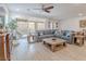 Bright living room with a large grey sectional, stylish wood tile floors, and sliding glass doors to the patio at 3503 Luca Point Ave, Henderson, NV 89044