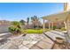 Landscaped backyard features a covered patio, green lawn, stone accents and mature plants at 3658 Ambergate Ct, Las Vegas, NV 89147