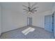 Bright bedroom with plush gray carpet, modern ceiling fan, and a view into the hallway at 376 E Erin St # 1, Pahrump, NV 89048