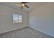 Bright bedroom with plush carpet, neutral walls, a ceiling fan, and a large window overlooking the neighborhood at 376 E Erin St # 1, Pahrump, NV 89048