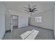 Bright bedroom with gray carpet, fan, ample natural light, and adjoining bathroom at 376 E Erin St # 1, Pahrump, NV 89048