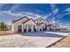 Modern townhomes featuring white stucco, dark trim, covered entries, and concrete driveway under a vibrant blue sky at 376 E Erin St # 1, Pahrump, NV 89048