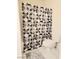 Bathroom with white tiled walls, toilet, and shower with patterned curtain at 4006 Morning Peace St, Las Vegas, NV 89115