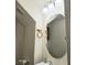 Bathroom with a round mirror and a three-light vanity fixture at 4006 Morning Peace St, Las Vegas, NV 89115