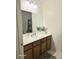 Bathroom with white sink, three pane mirrored cabinet, and wood cabinet at 4006 Morning Peace St, Las Vegas, NV 89115