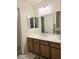 Bathroom with white sink, three pane mirrored cabinet, and wood cabinet at 4006 Morning Peace St, Las Vegas, NV 89115