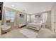 Bedroom with neutral tones, complemented by ample natural light and a faux fur covered bench and rug at 4340 Hatch Bend Ave, North Las Vegas, NV 89031