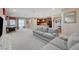 Open-concept living room with plush seating, light-colored carpet, and seamless flow to kitchen area at 4340 Hatch Bend Ave, North Las Vegas, NV 89031