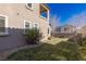 Side view of a backyard with green lawn, bordered by rock and next to the tan home at 436 Trevinca St, Las Vegas, NV 89138