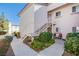 Exterior view of a condo features upstairs access via stairs, landscaping, and a sidewalk at 4555 E Sahara Ave # 132, Las Vegas, NV 89104