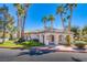 Charming single-story building featuring an arched entryway, lush landscaping, and towering palm trees against a clear blue sky at 4555 E Sahara Ave # 132, Las Vegas, NV 89104