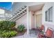 Exterior view of a condo features stairs, chairs on the landing, and landscaping at 4555 E Sahara Ave # 132, Las Vegas, NV 89104