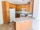 Bright kitchen with wood cabinets, white appliances, and breakfast bar at 4905 Morning Falls Ave, Las Vegas, NV 89131