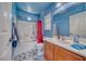 This vibrant bathroom features a blue accent wall, a large vanity and a shower-tub combo at 5179 Floralita St, Las Vegas, NV 89122