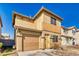 Two-story home features a tan stucco exterior, garage, and well-lit front entrance, creating a welcoming curb appeal at 5179 Floralita St, Las Vegas, NV 89122