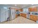 Well-lit kitchen featuring stainless steel appliances, wood cabinets, and laminated flooring at 5179 Floralita St, Las Vegas, NV 89122