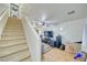 Open-concept living room featuring staircase, neutral walls, ceiling fan, and modern entertainment system at 5179 Floralita St, Las Vegas, NV 89122