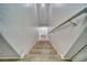 Carpeted staircase leading down to a hallway with a white door and light fixture at 5179 Floralita St, Las Vegas, NV 89122