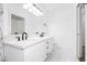 Bright bathroom with a double sink vanity, modern fixtures, and white and geometric patterned walls at 5225 W Reno Ave # 105, Las Vegas, NV 89118