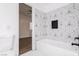 Bathroom showcasing tub with geometric-patterned tile, black hardware and a small stone niche at 5225 W Reno Ave # 105, Las Vegas, NV 89118