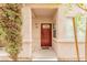 Charming condo entrance with a red door, textured walls, covered porch, and unit number 105 at 5225 W Reno Ave # 105, Las Vegas, NV 89118