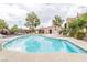 Community pool with clear blue water, surrounding lounge chairs, restroom and trees at 5225 W Reno Ave # 105, Las Vegas, NV 89118