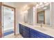 Bathroom features double sink vanity with blue cabinets and a large walk-in shower at 536 Greenbriar Pl, Boulder City, NV 89005